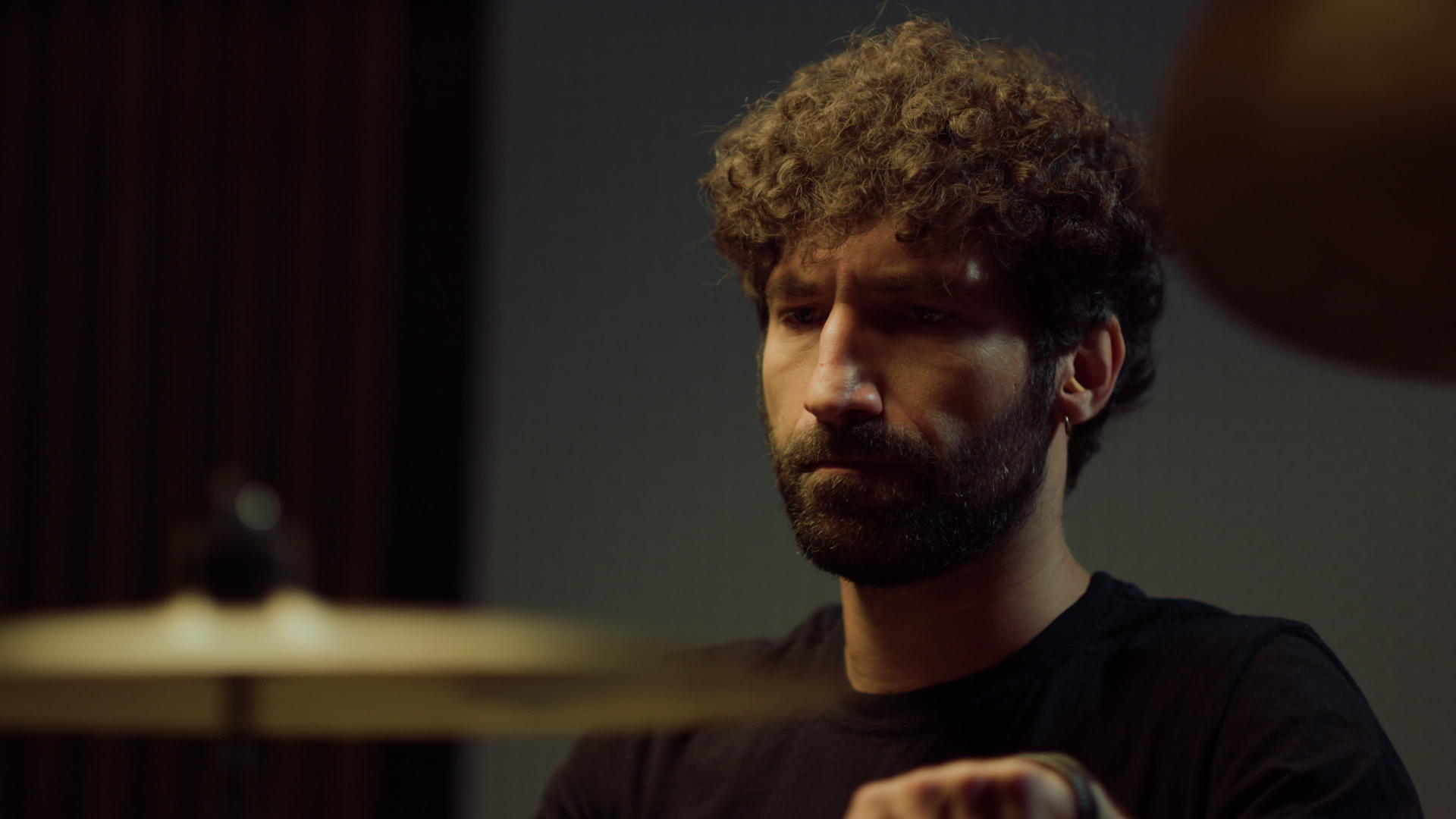 在录音室里留胡子的鼓手使用铜独奏的肖像视频的预览图