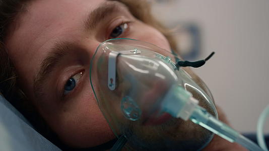 病人戴着氧气面具躺在急救车的担架上视频的预览图