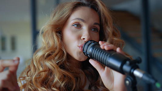 在麦克风里唱歌的女人音乐家在音乐的节奏中弹奏手指视频的预览图