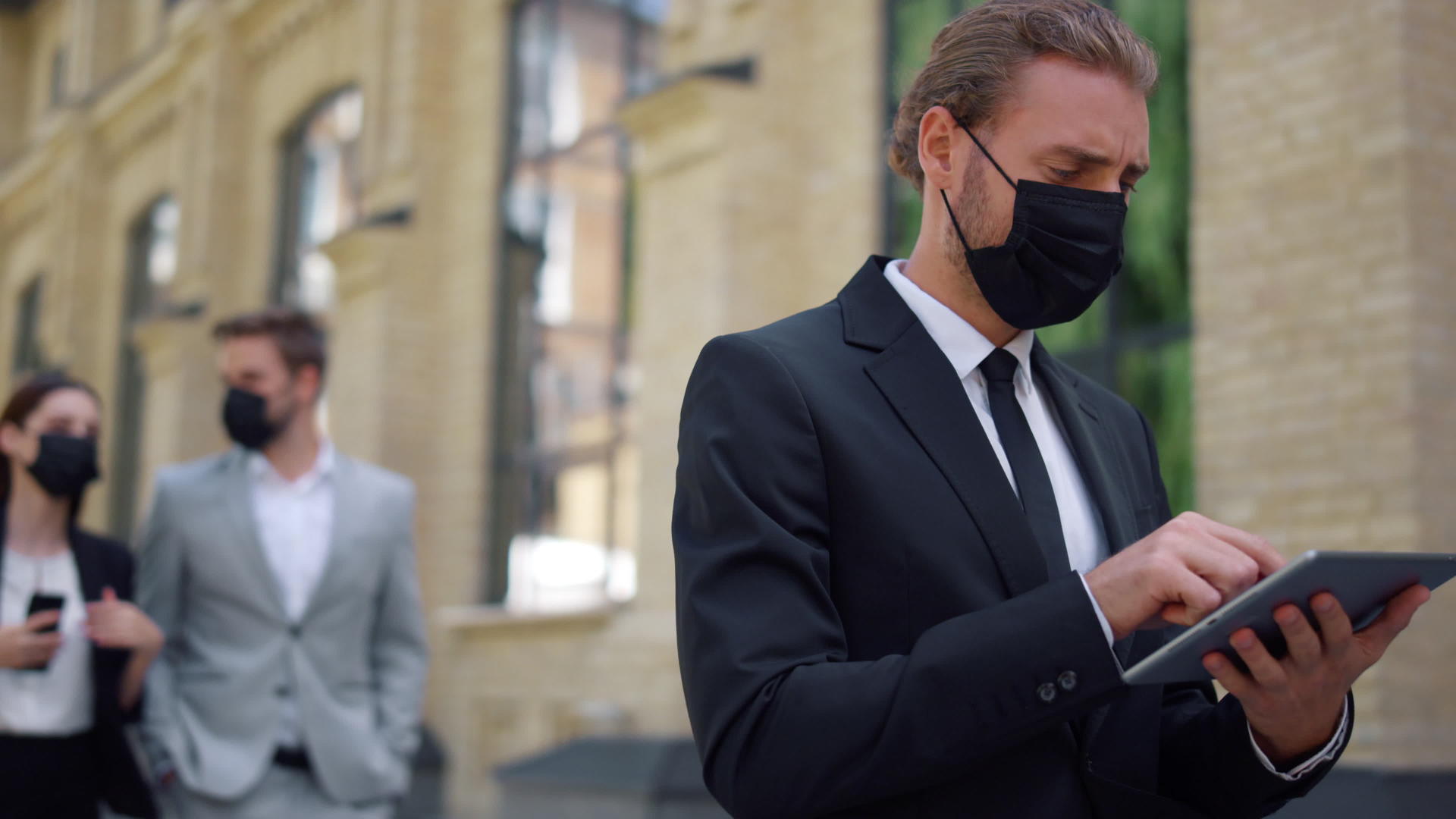 戴口罩的商人使用平房室外工具西装男有社交距离视频的预览图
