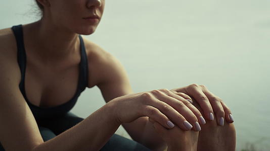 女性坐在青山海边锻炼瑜伽视频的预览图