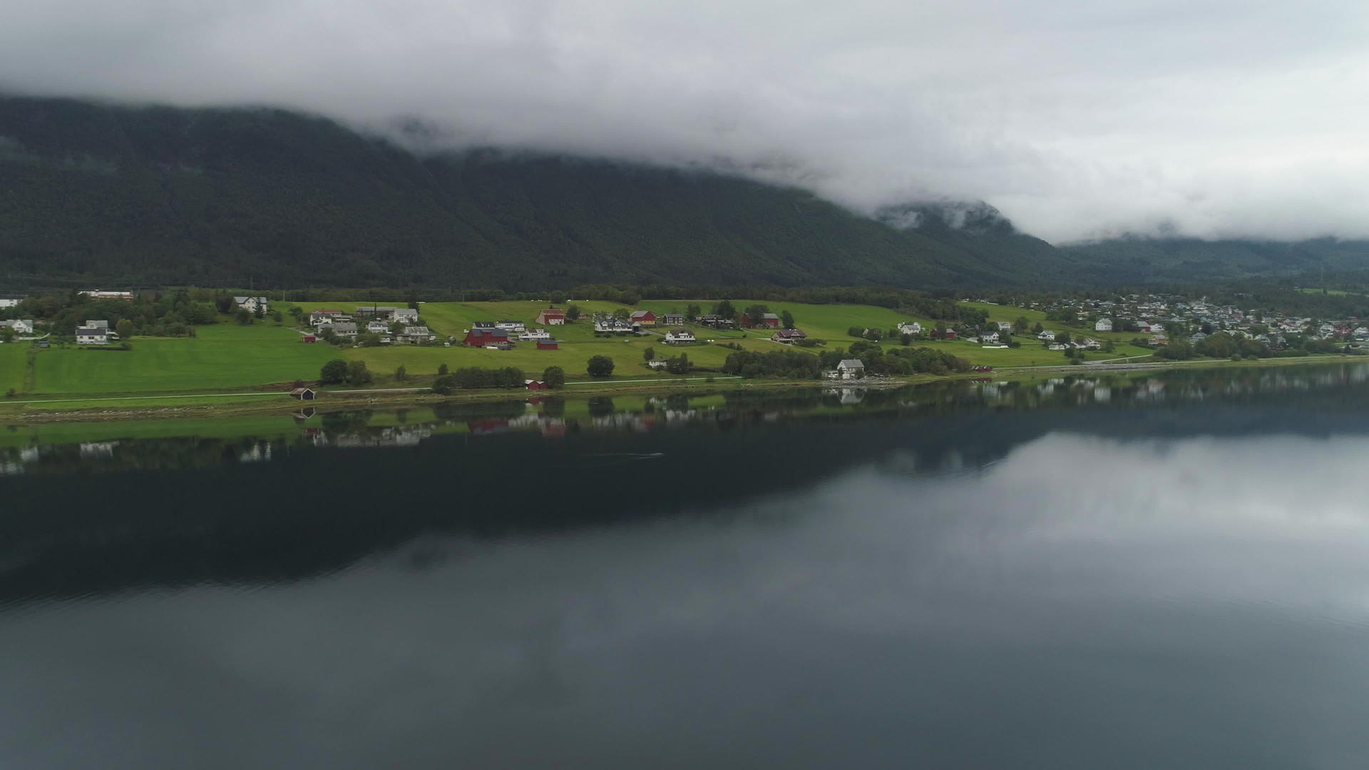小镇和湖中的倒影夏天多云的挪威绿色景观鸟瞰无人机视频的预览图
