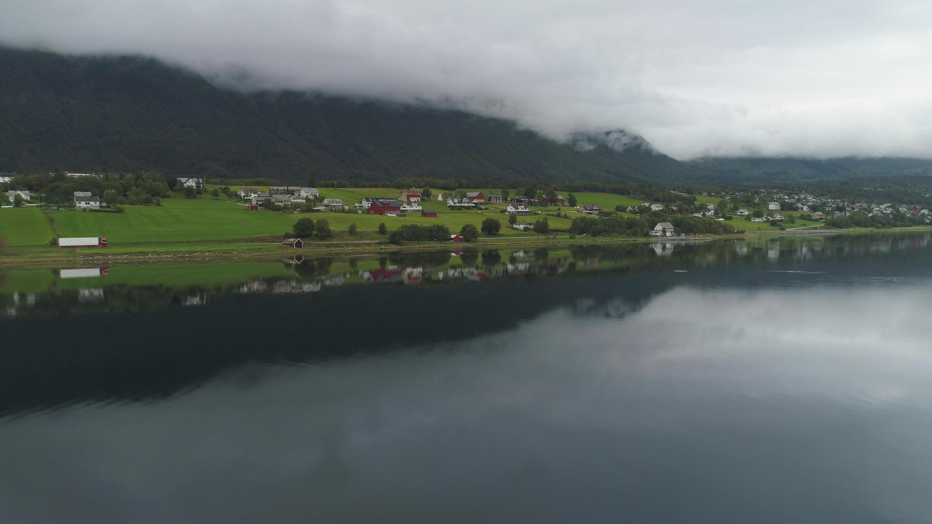 小镇和湖面反射了许多云观察了夏日诺威的绿色景观视频的预览图
