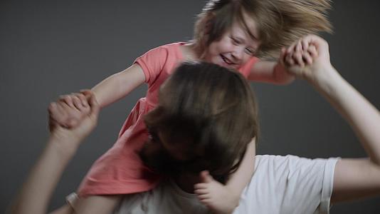 年轻的父亲骑在父亲身上把女儿扔在父亲的背上视频的预览图