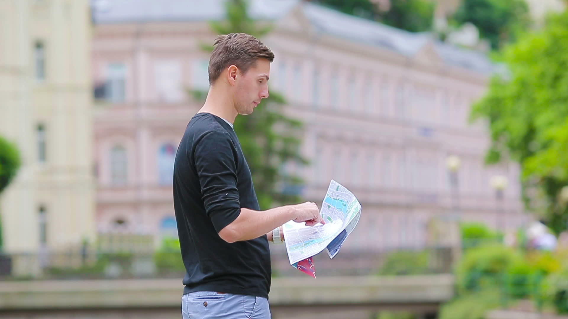 Caucasian男孩看着欧洲城市的地图寻找目的地视频的预览图