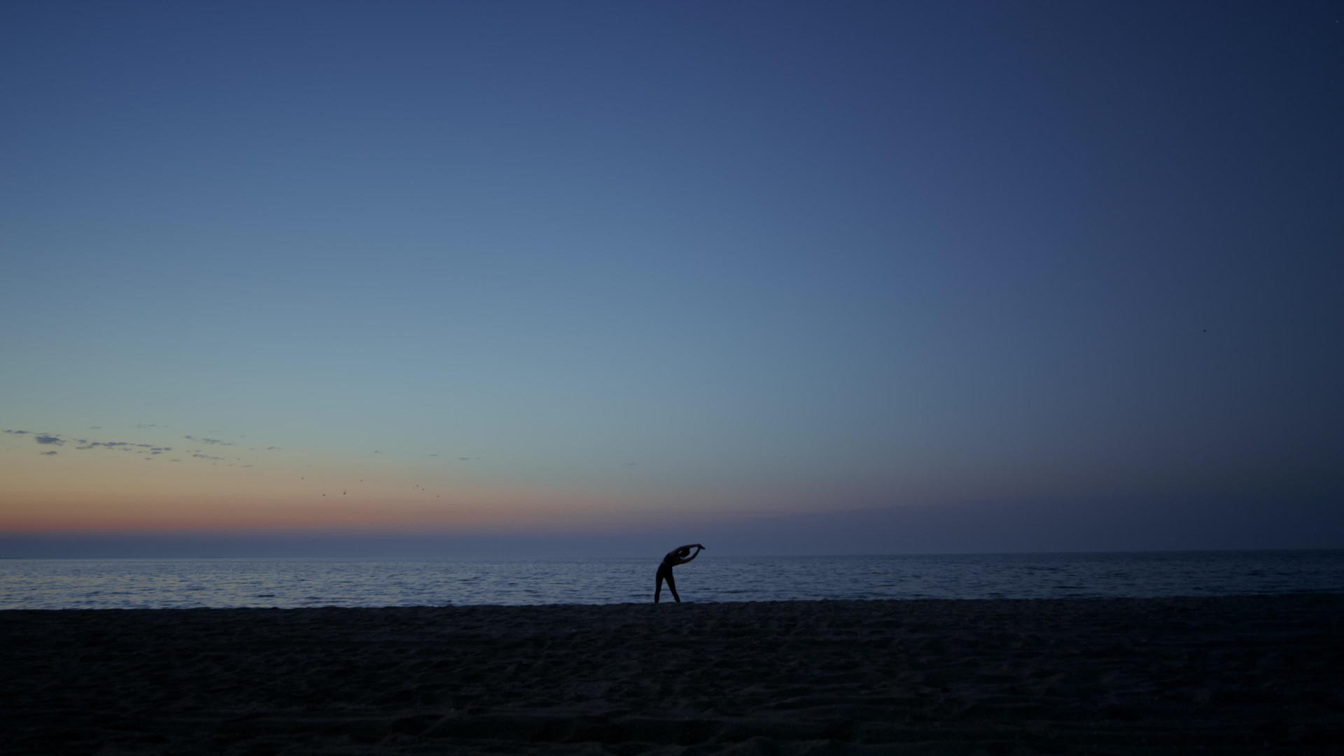 黄昏时分在海岸上锻炼剪影运动员女孩视频的预览图