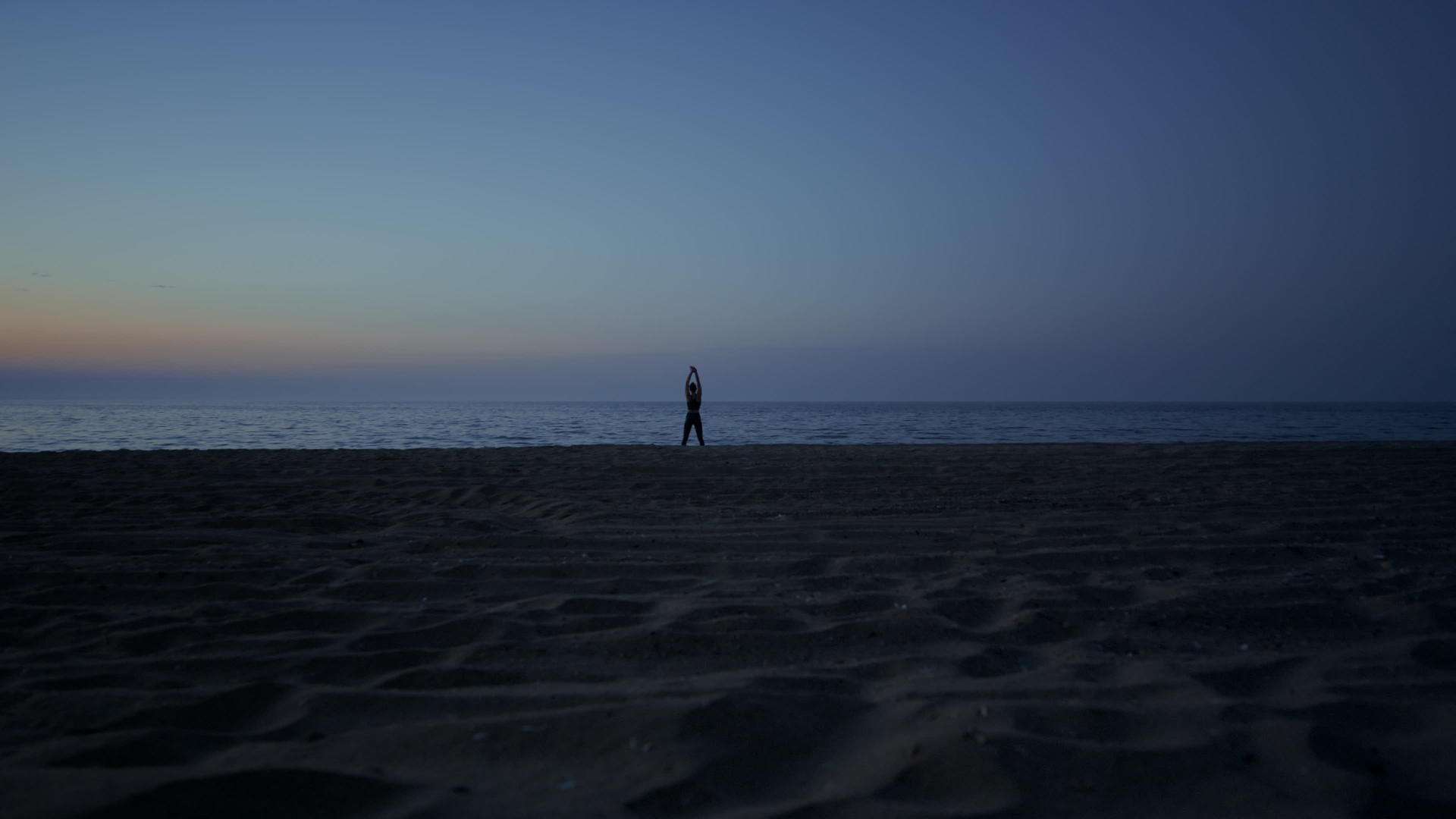 深夜在沙滩上做瑜伽的剪影女人视频的预览图