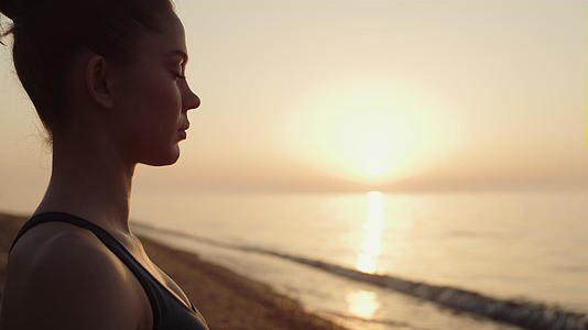 配置文件女运动员在沙滩cposeup上进行冥想练习视频的预览图
