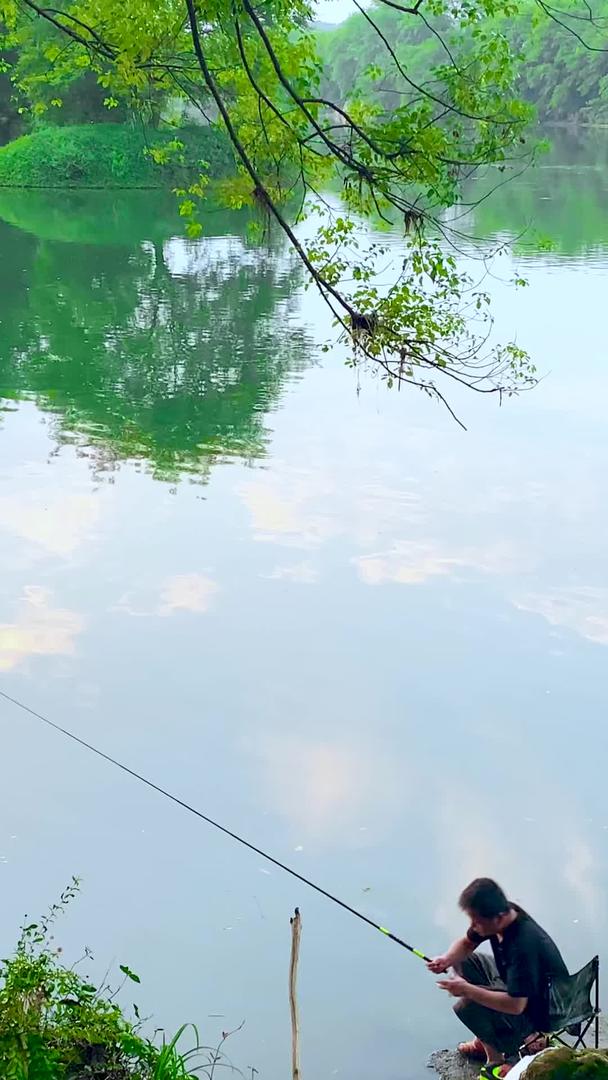 田园里夕阳下波光粼粼的湖面钓鱼者视频的预览图
