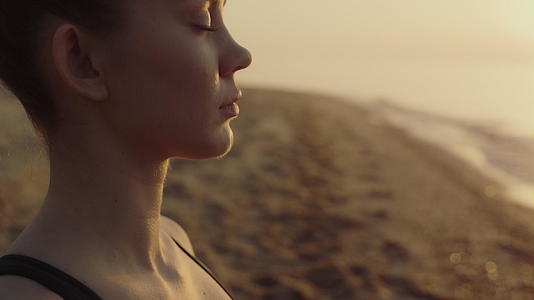 瑜伽女人在沙滩上冥想闭上眼睛视频的预览图