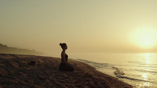 瑜珈妇女在沙滩上练习冥想视频的预览图