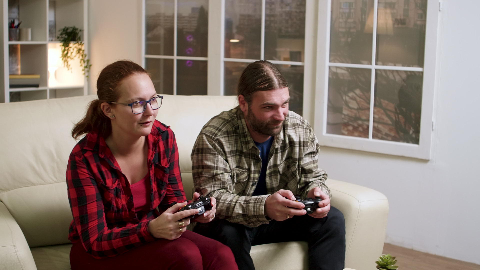 快乐的年轻情侣在玩电子游戏的同时庆祝他们的胜利视频的预览图