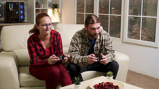 男女坐在沙发上玩电子游戏视频的预览图