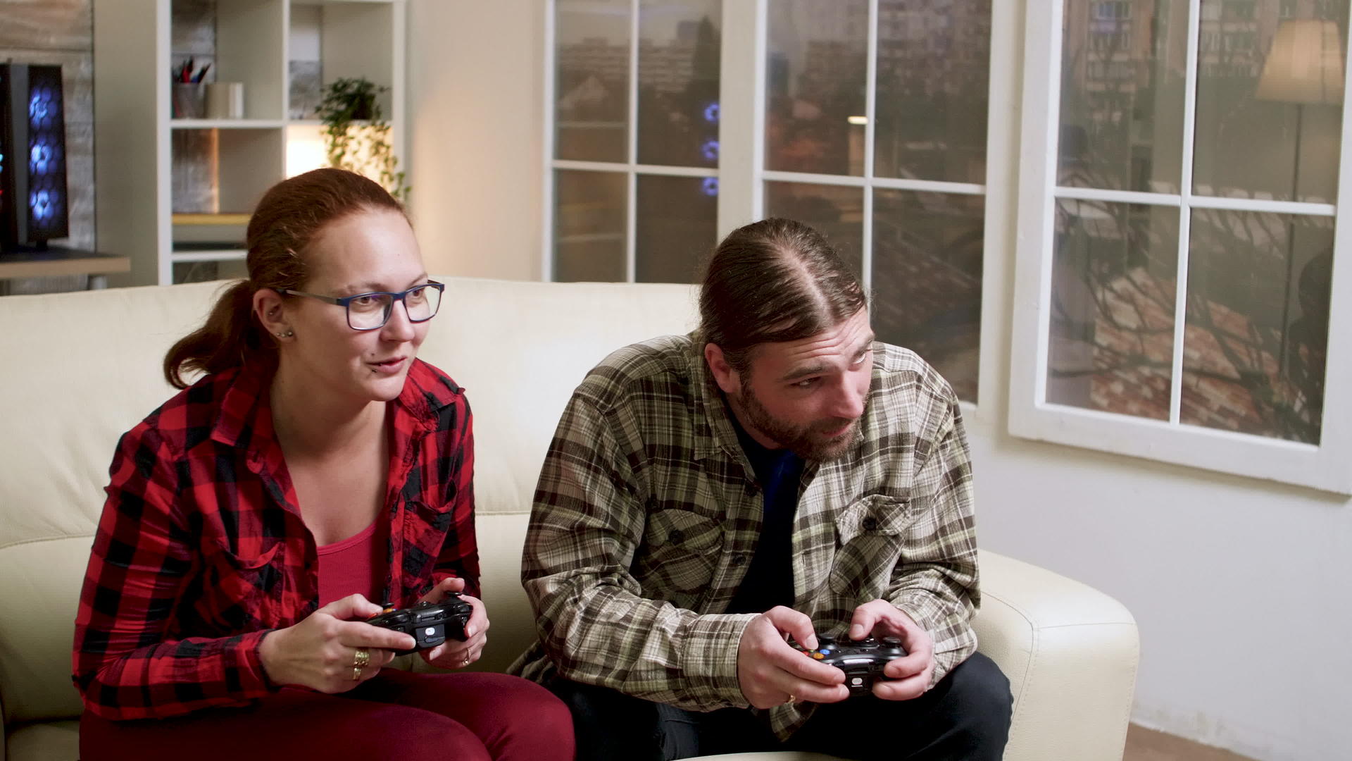 情侣们坐在沙发上玩电子游戏视频的预览图