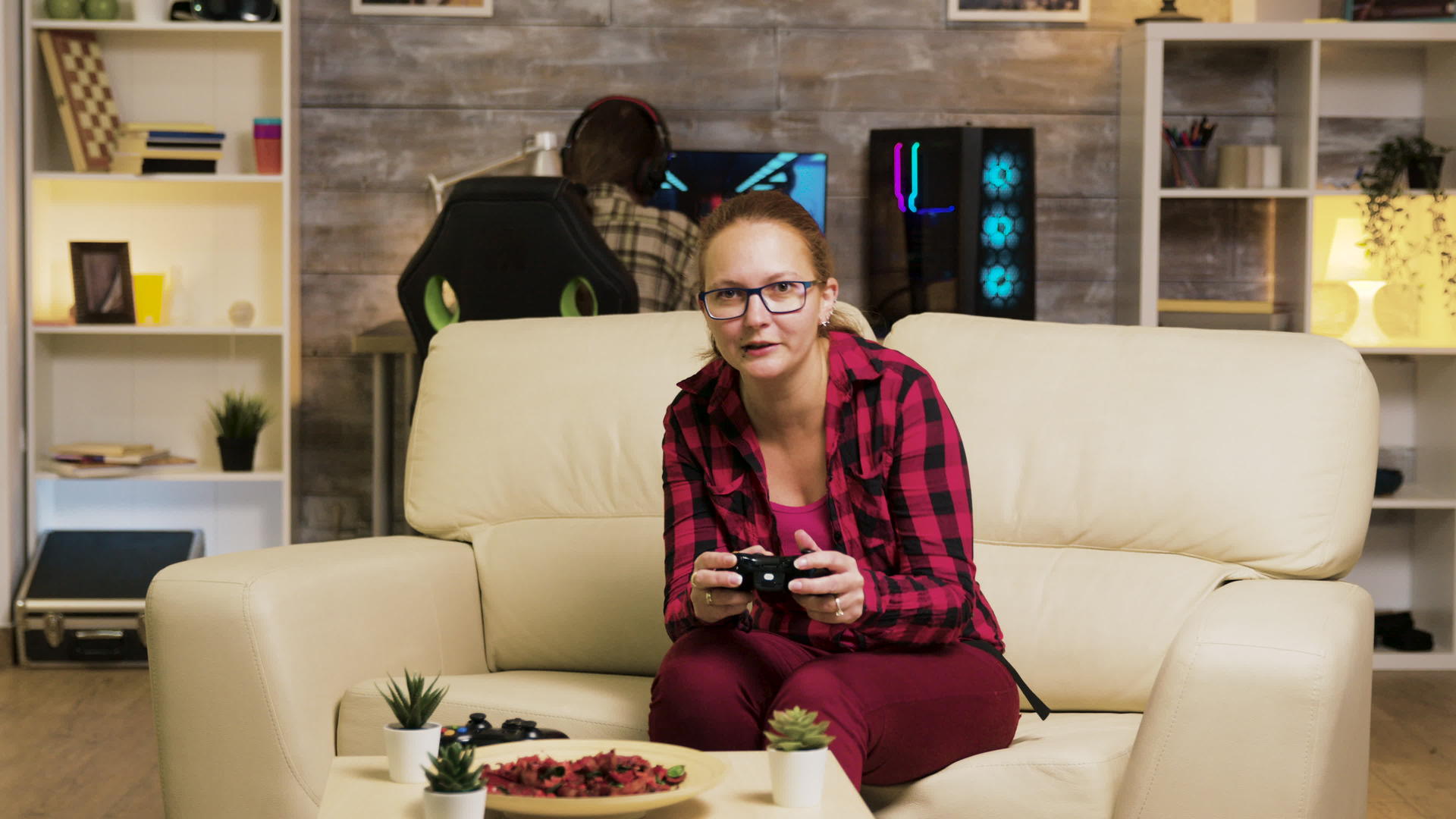 女人坐在客厅的沙发上玩电子游戏视频的预览图