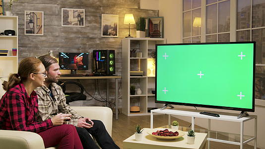 放松夫妇坐在沙发上玩电子游戏视频的预览图