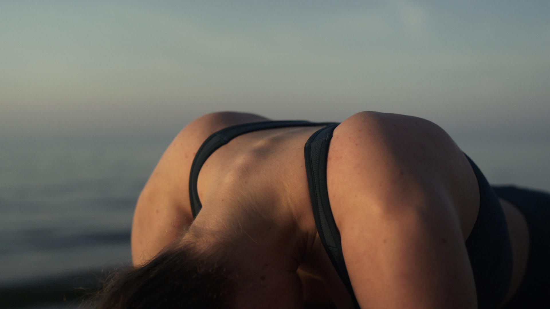 运动型女孩在沙滩山上做体操视频的预览图