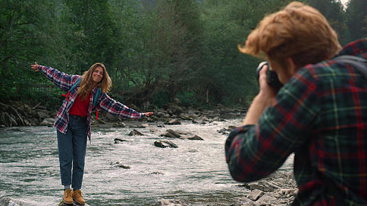 在河边拍摄女性的摄影师视频的预览图