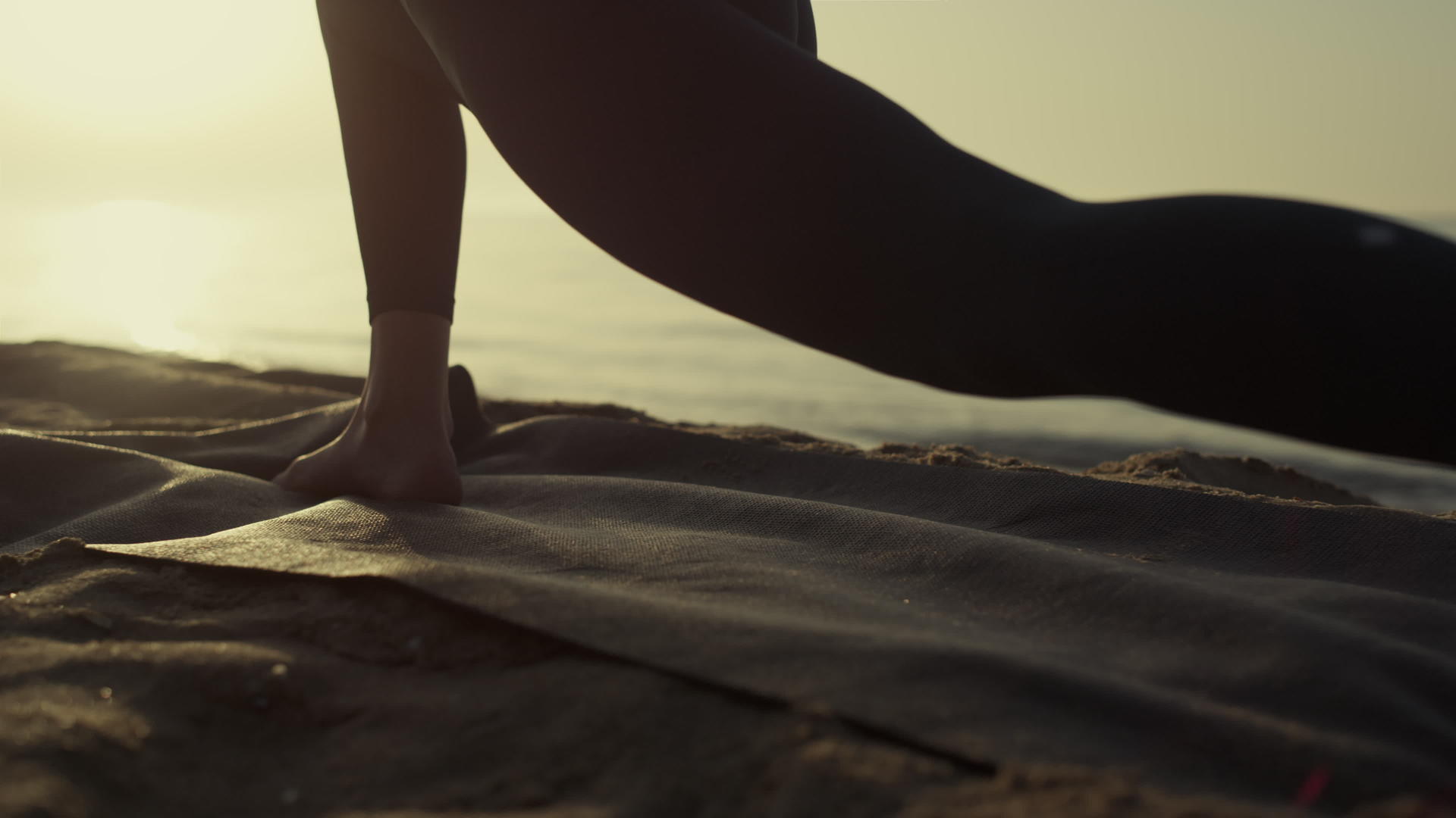 瑜珈女人的腿在海滩特写上伸展展开视频的预览图