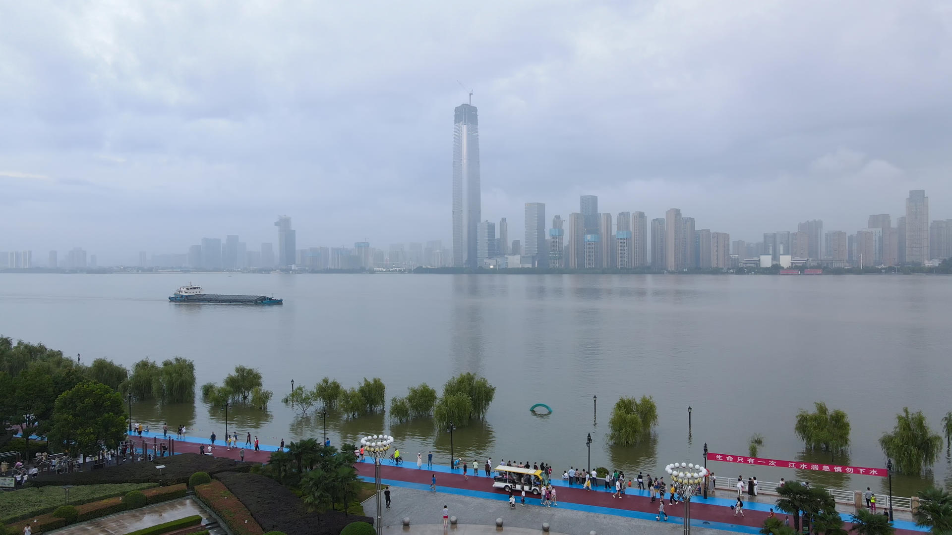 航拍风光城市长江汛期洪峰过后在堤坝上看江水上涨的游客人群素材视频的预览图