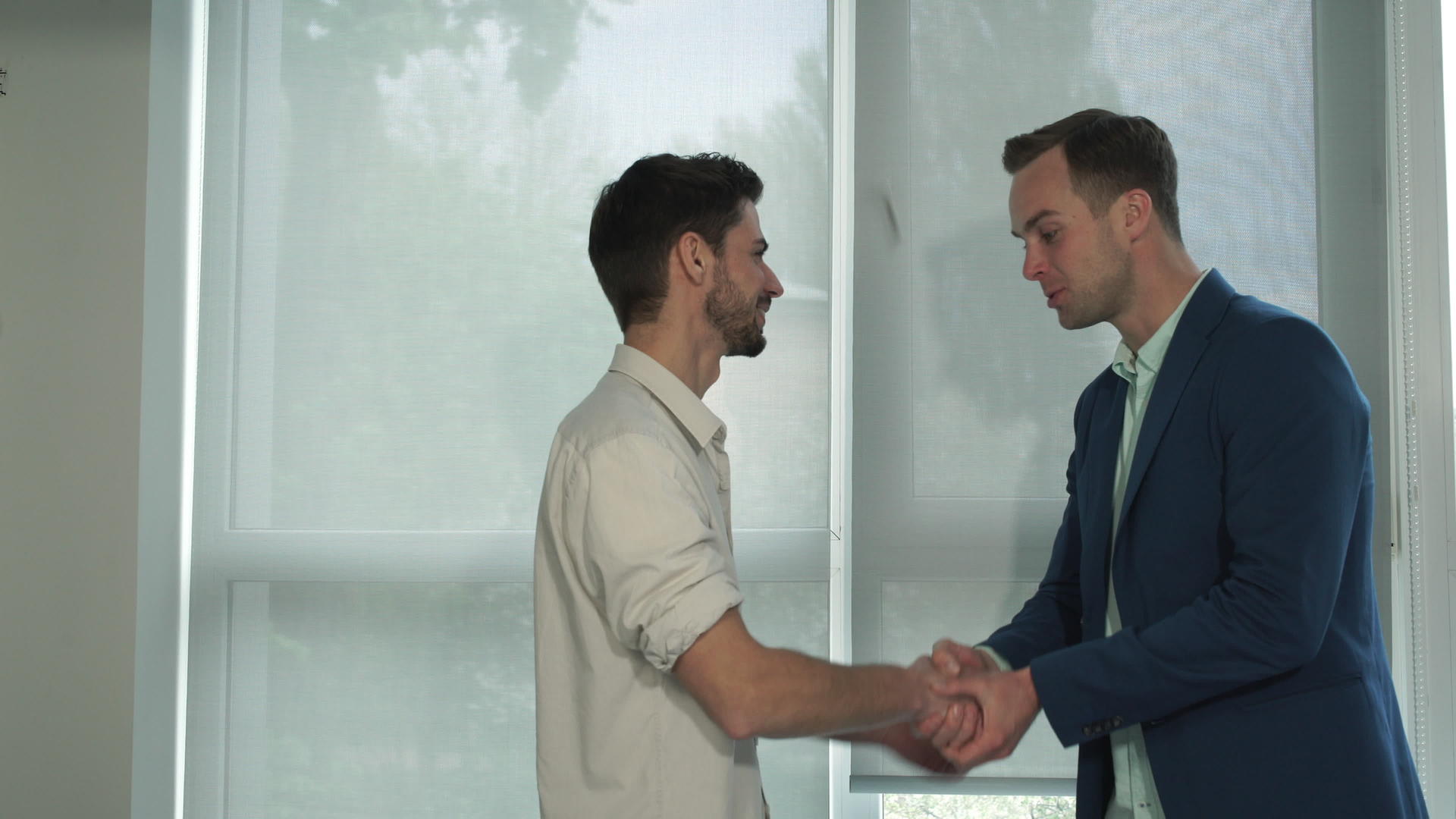 两名年轻职业男子握手打招呼视频的预览图