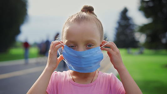 可爱的小女孩戴上口罩防疫措施视频的预览图