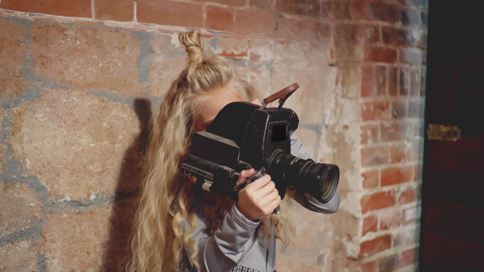 年轻女性视频操作员持有黑色相机视频的预览图