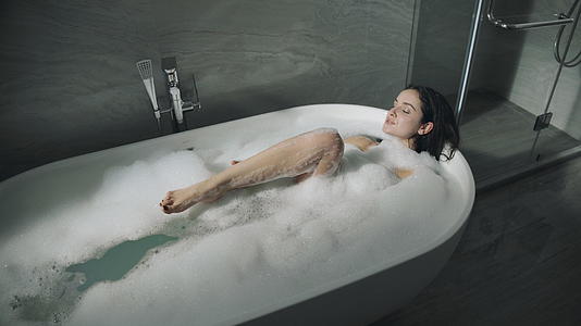 漂亮的女人在室内洗泡泡浴视频的预览图