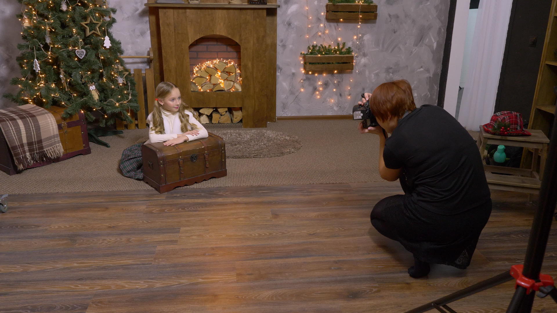 女摄影师拍摄圣诞树和壁炉的背景视频的预览图