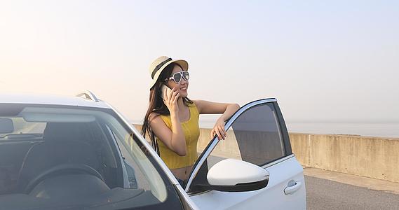 女性在车边接打电话视频的预览图
