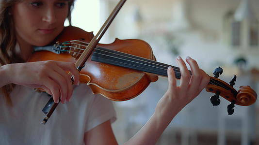 女孩用弓拉小提琴女小提琴家演奏音乐作品视频的预览图
