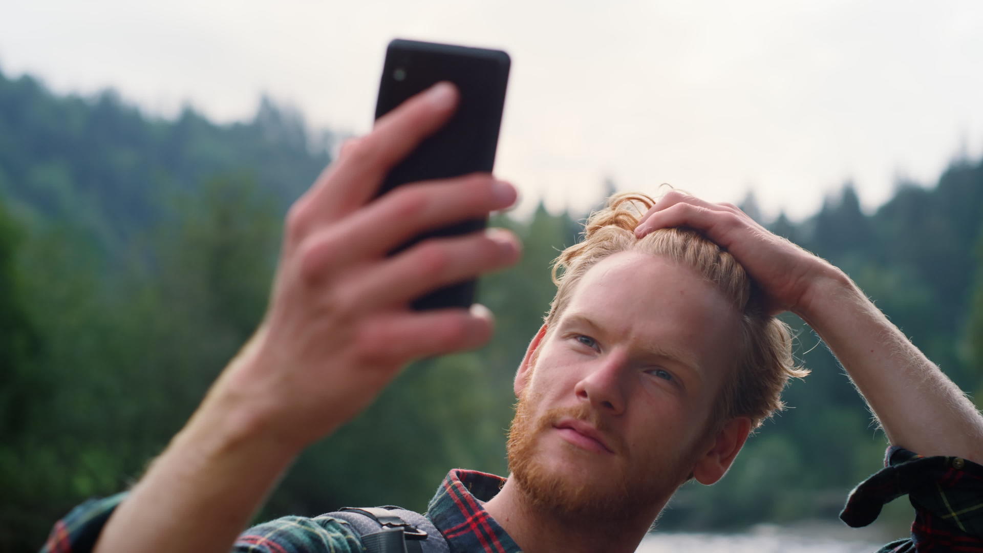 在高山的智能手机上自拍的家伙视频的预览图