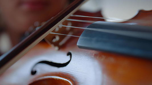 年轻女子手拉小提琴女孩用小提琴弓视频的预览图