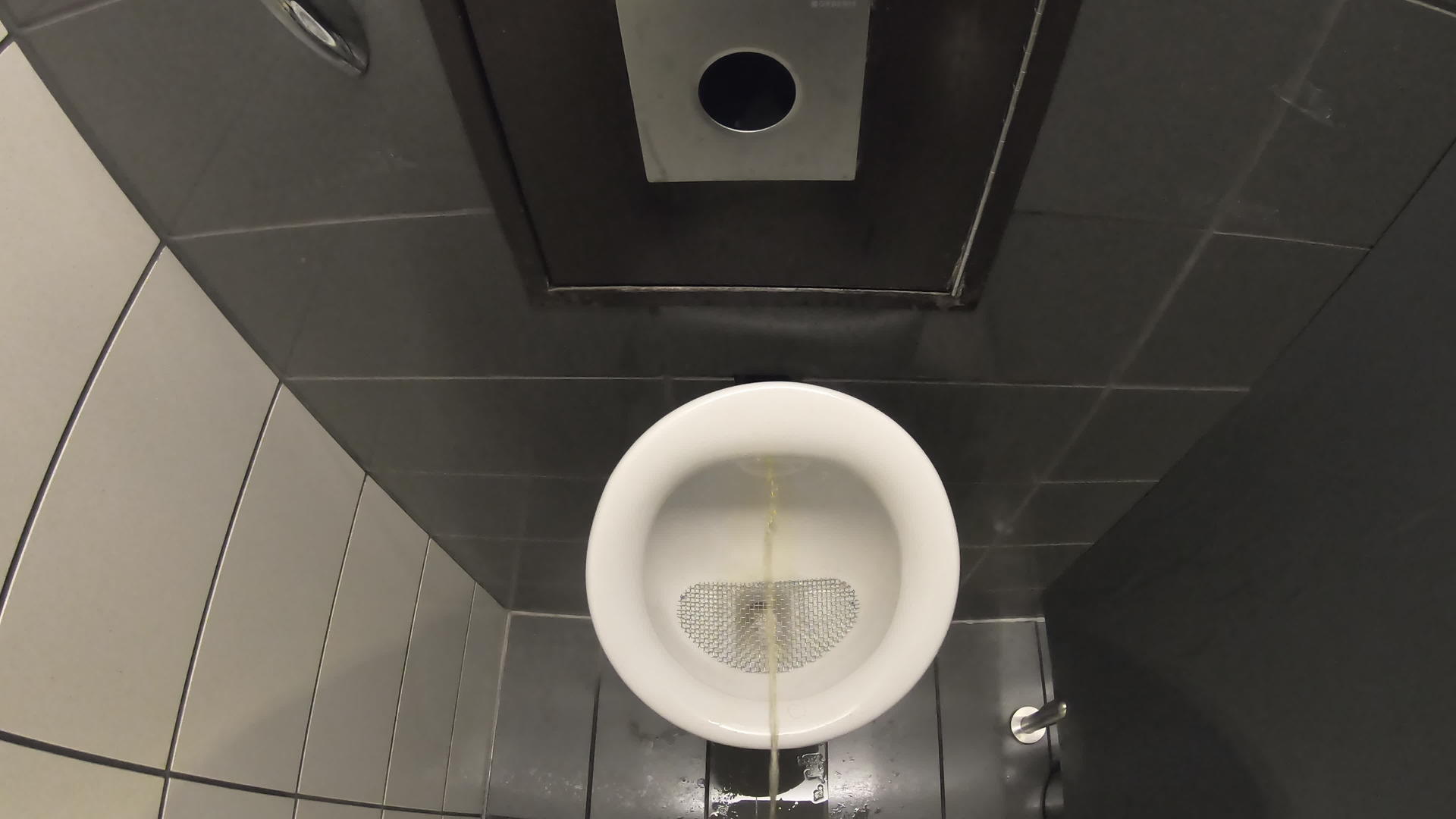 从第一个角度看年轻人在公共厕所里撒尿站在贸易中心的小便池旁边视频的预览图