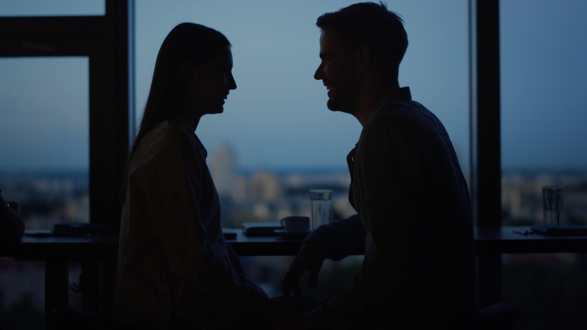 年轻夫妇在全景窗前亲吻拥抱办公室的情侣视频的预览图