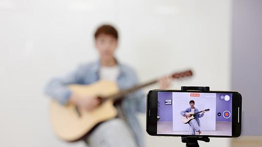 手机录制男孩弹吉他视频的预览图
