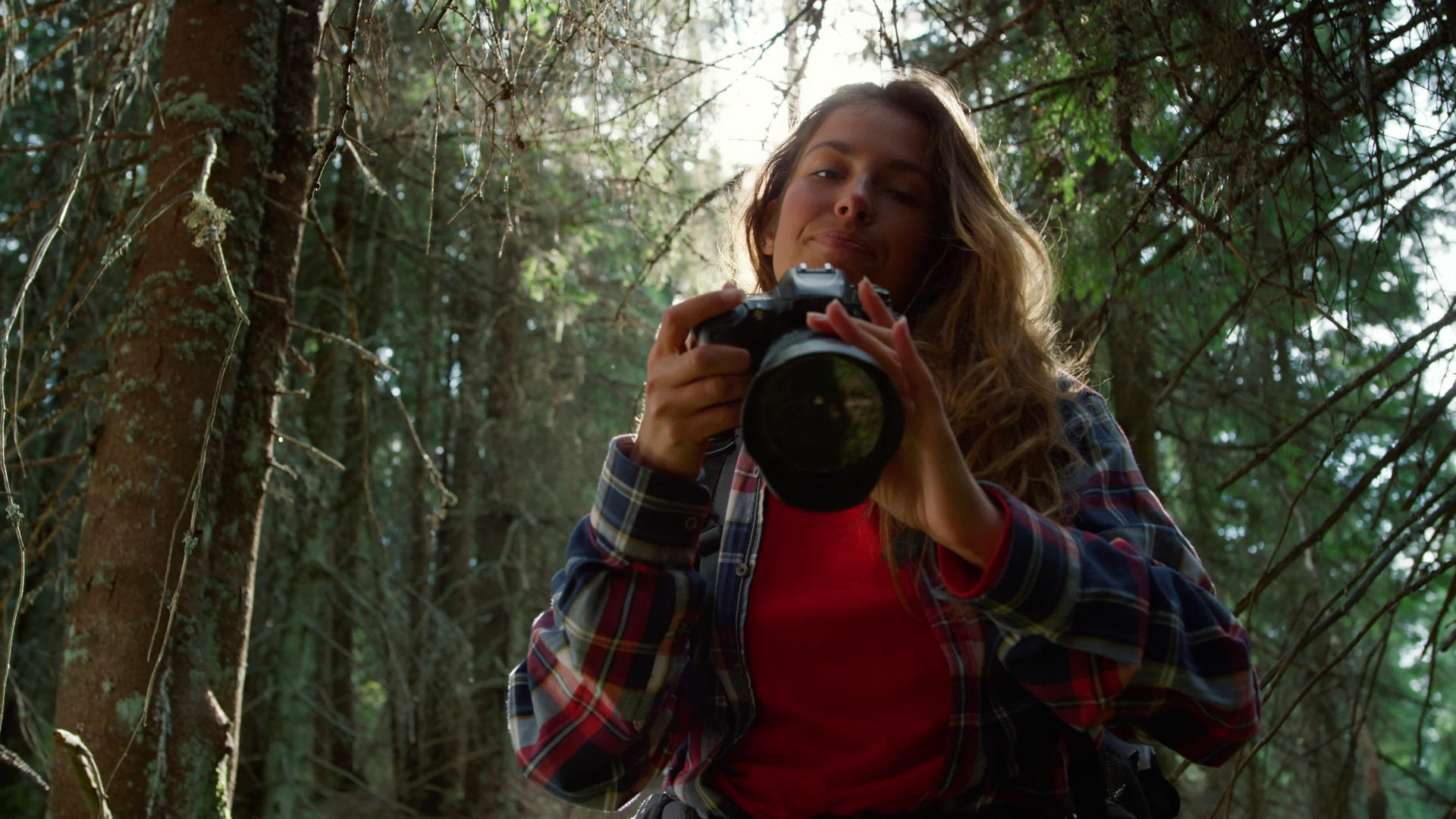 女摄影师拍摄森林景观视频的预览图