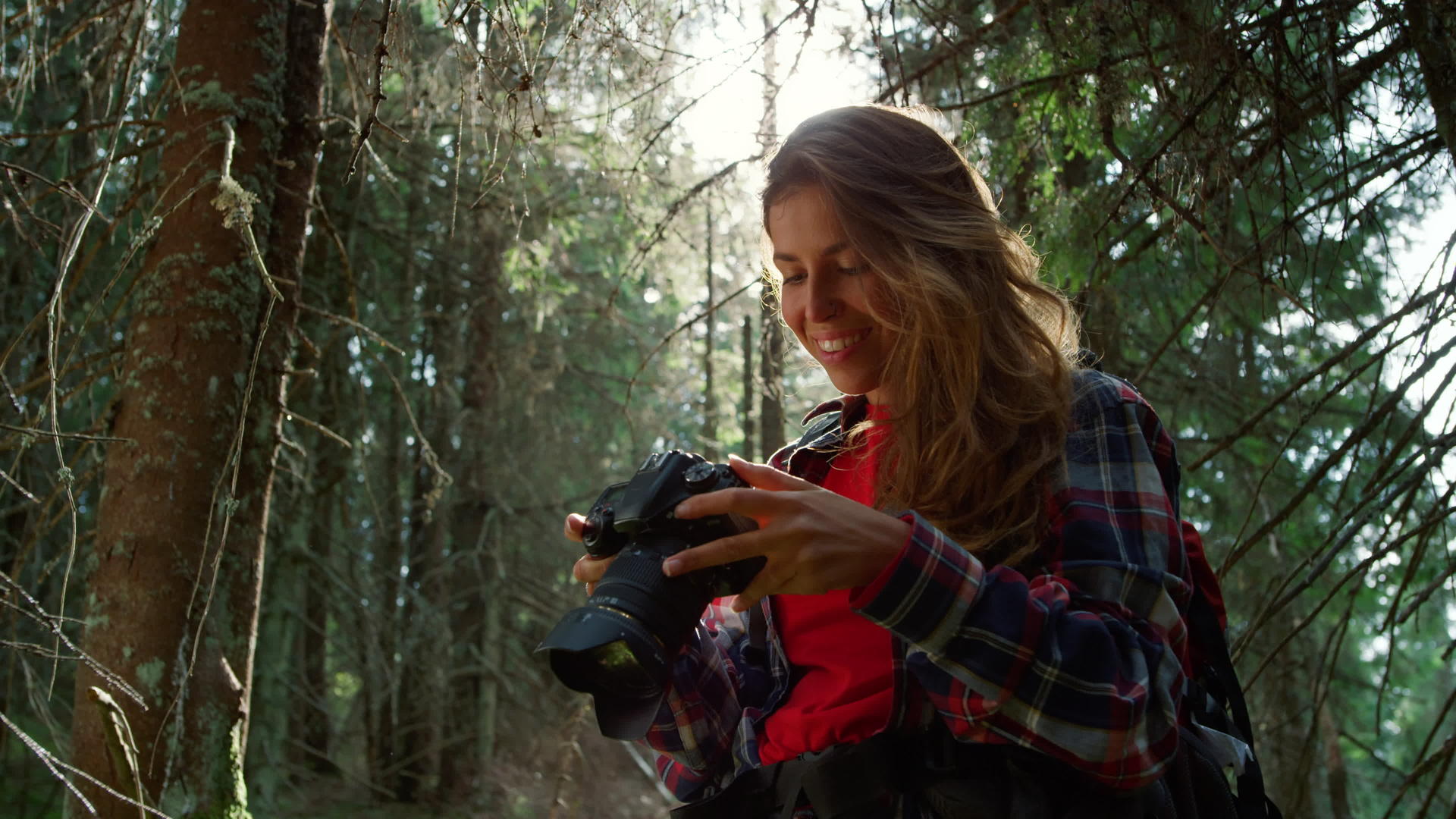 女孩带着相机站在森林里视频的预览图