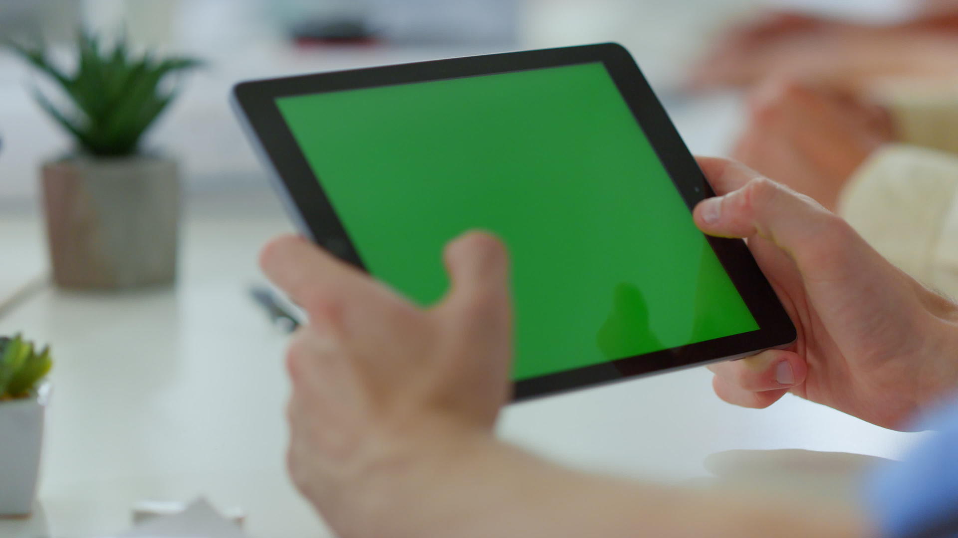 男性双手触摸室内绿色屏幕男人用数字装置携带武器视频的预览图