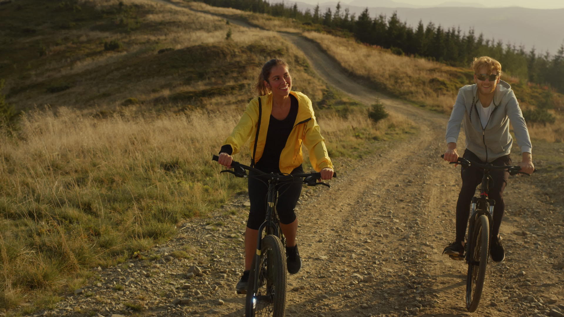 女人和男人在山路上骑自行车视频的预览图