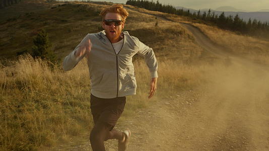 强壮的运动员在山上慢跑视频的预览图