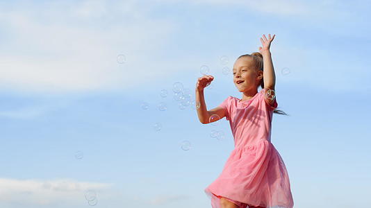 快乐女人在城市公园吹肥皂泡快乐女孩玩户外游戏视频的预览图