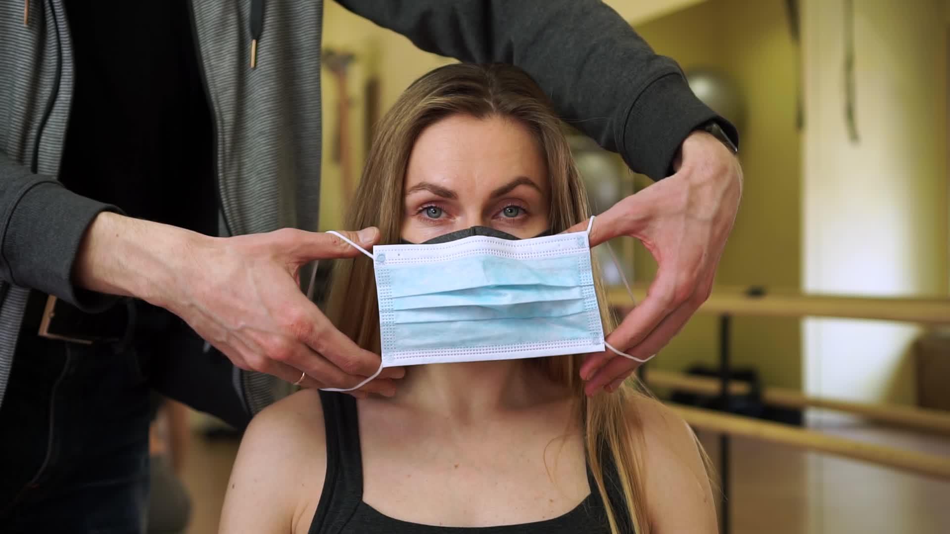 在科罗纳检疫期间一名男子在空体健身房给一名妇女穿上了一件衣服视频的预览图