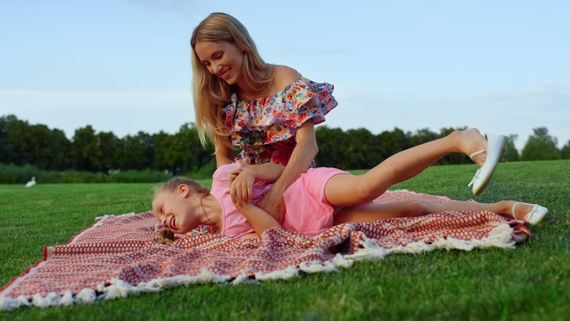 女人在市公园和儿子玩耍家庭享受草原日落视频的预览图