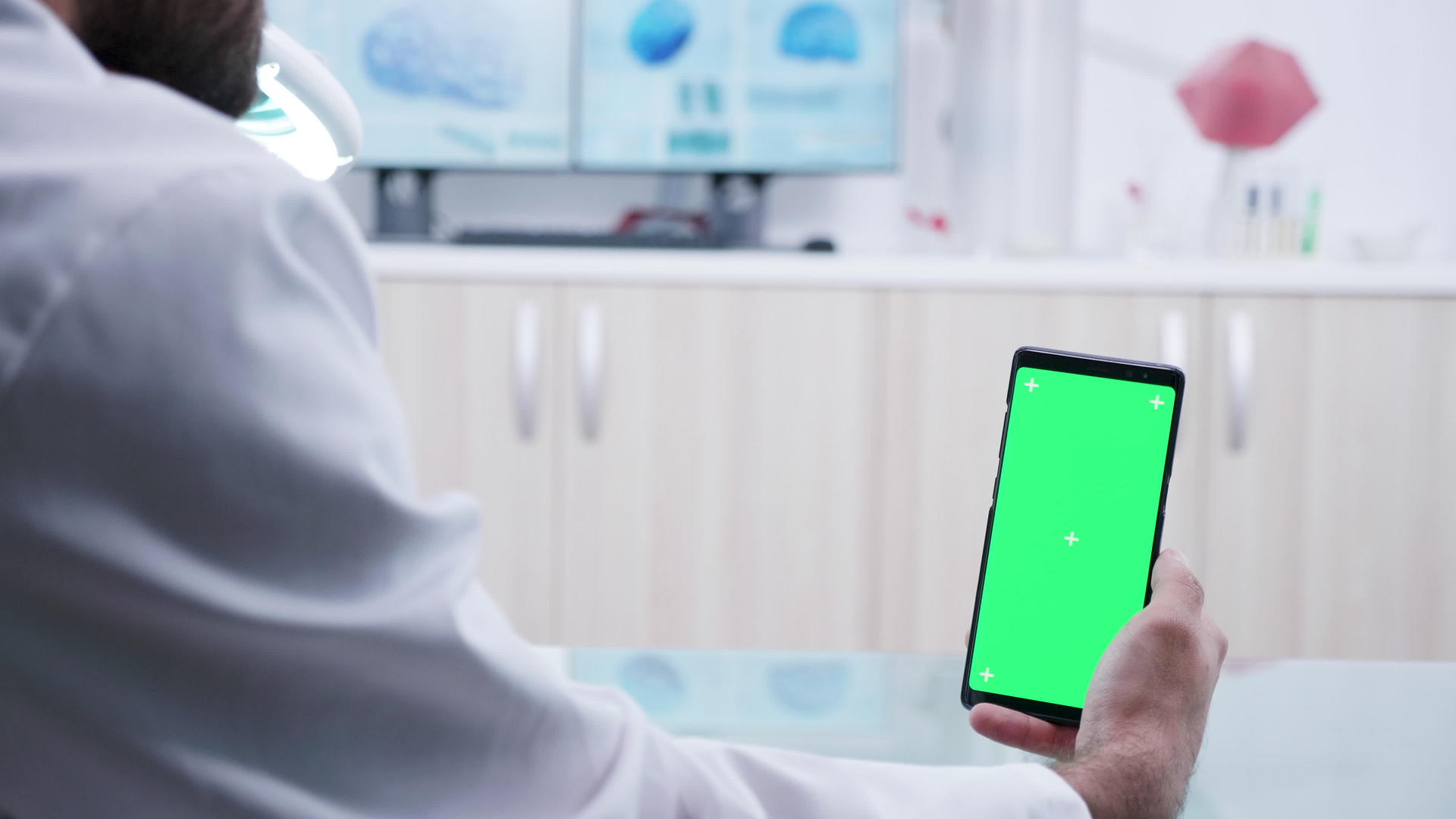 医生手里拿着一部绿色屏幕智能手机放大镜头视频的预览图