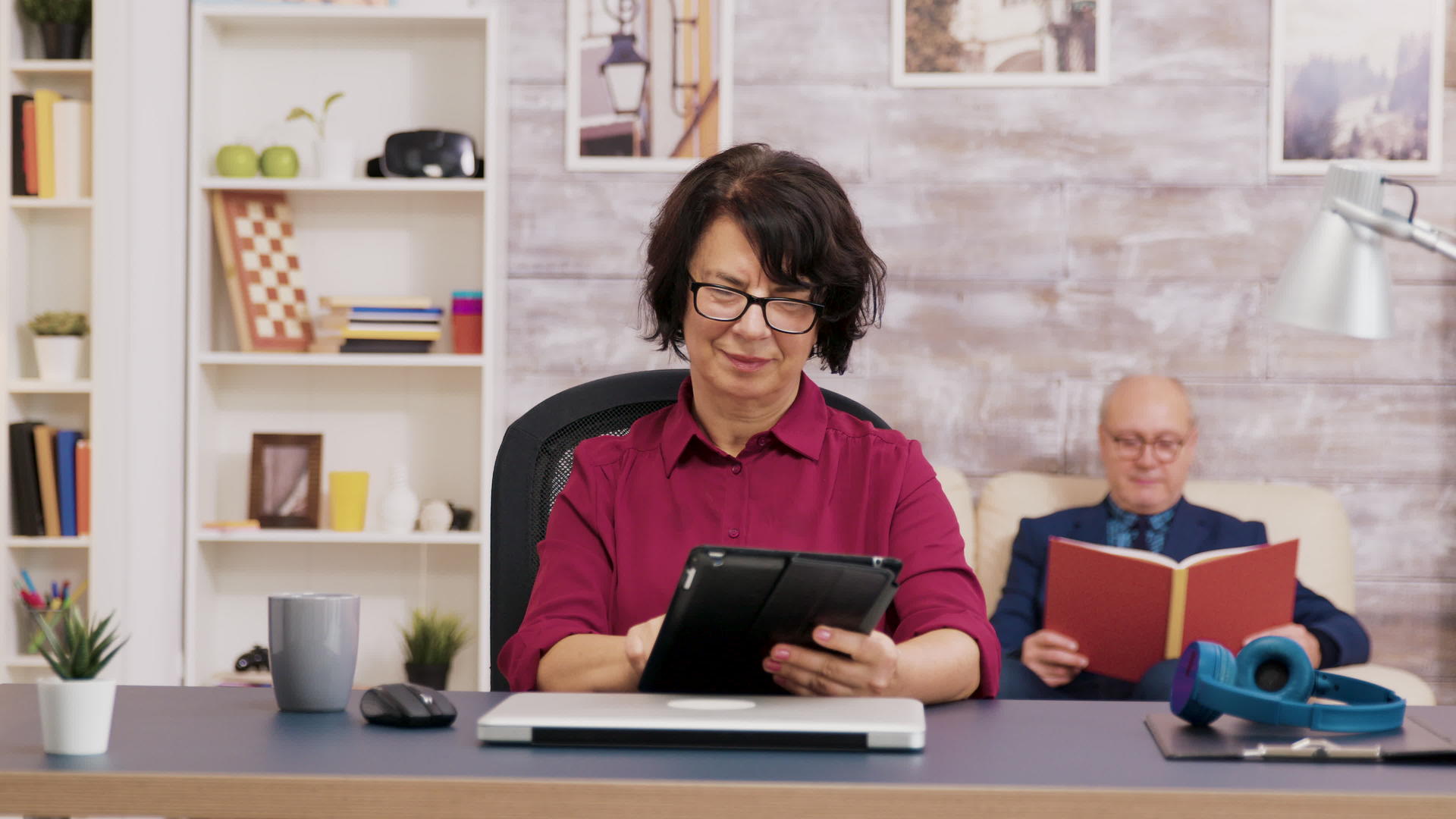 带眼镜的老年妇女在客厅使用平板电脑视频的预览图