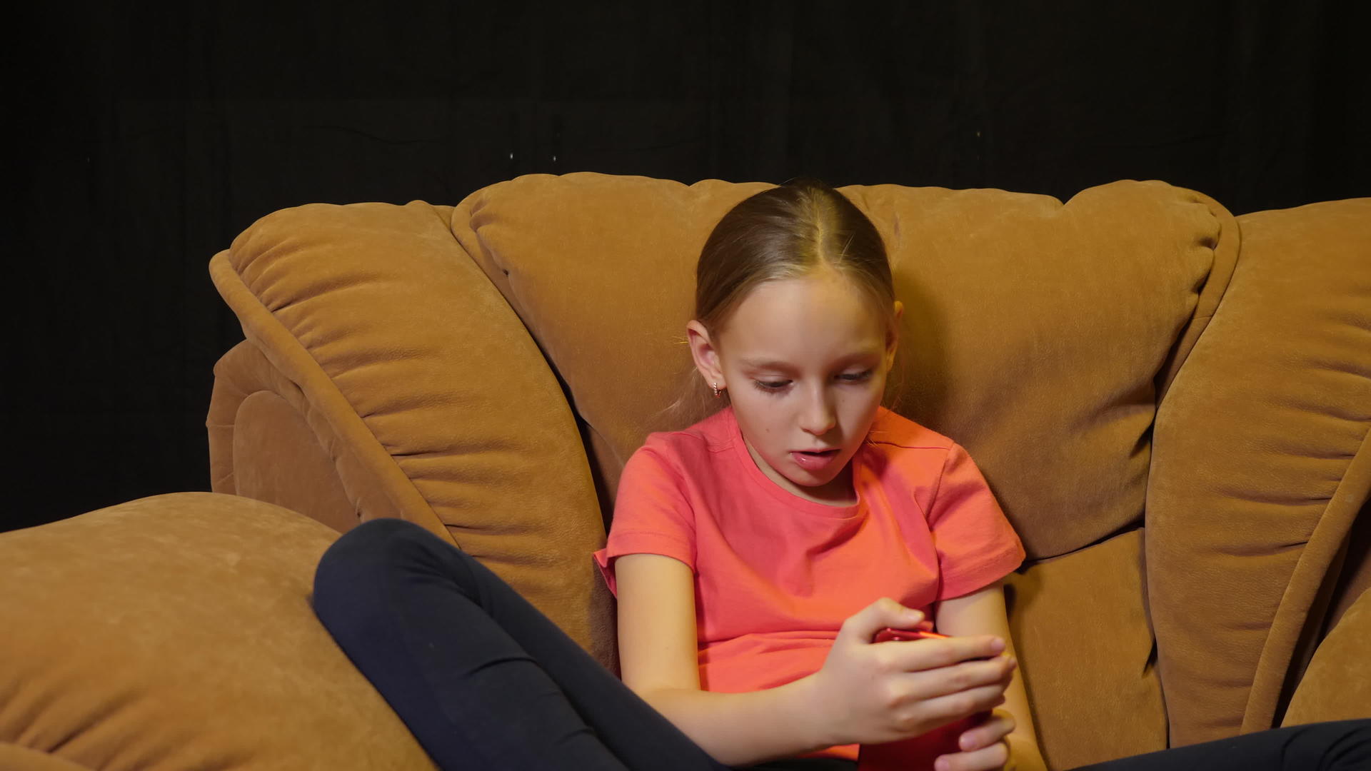 在家里的客厅里使用智能手机在舒适的椅子上使用放松的女孩视频的预览图