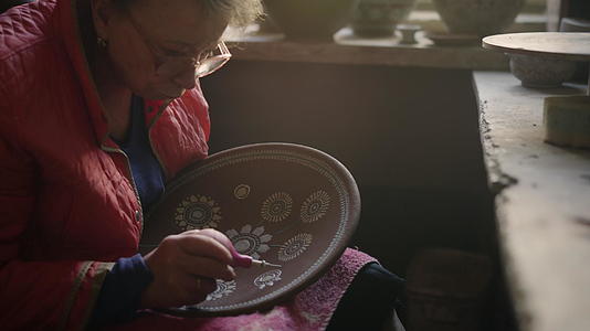 高级女性在陶器中画粘土板视频的预览图