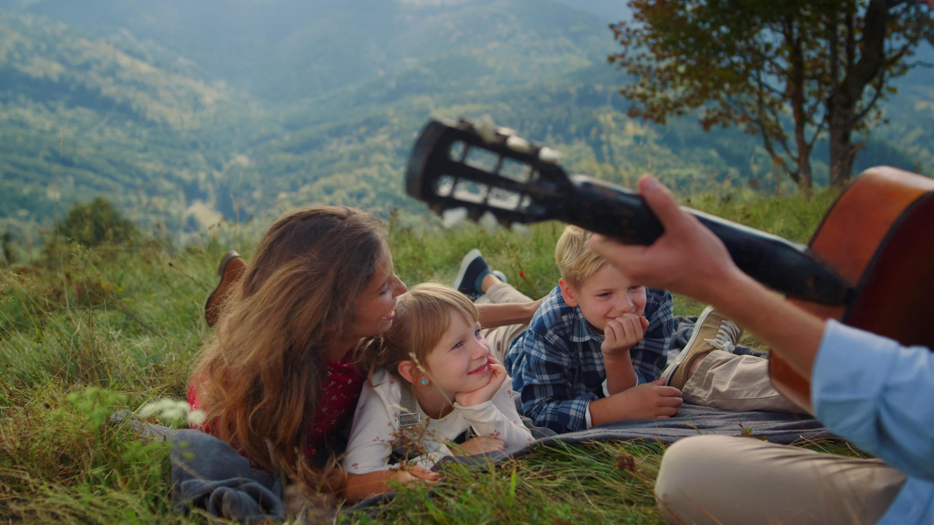 男士为妻子和孩子弹吉他野餐视频的预览图