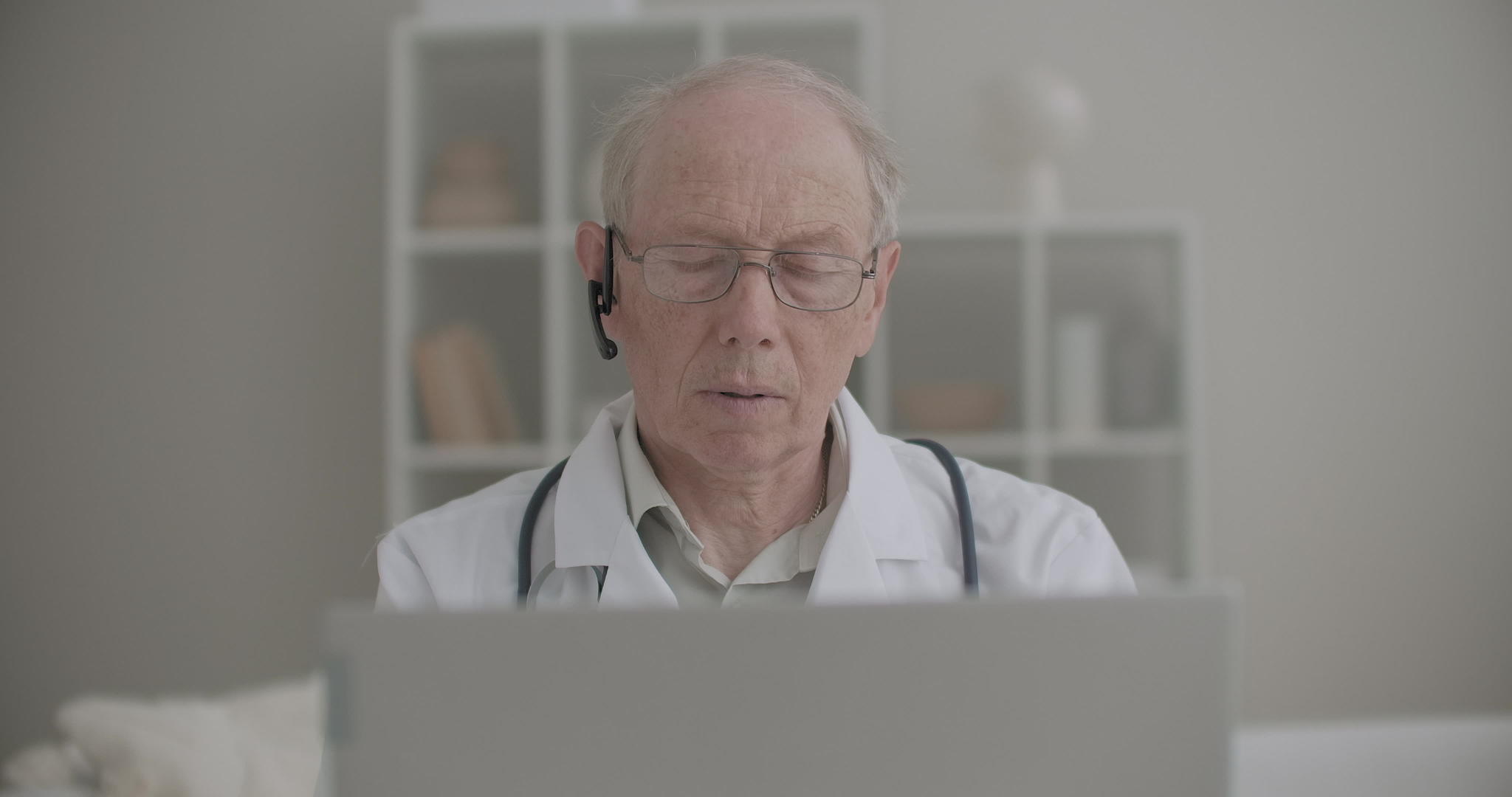 老年医学教授正在办公室里为病人和实习生使用笔记本电脑视频的预览图